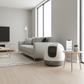 Sleek self-cleaning litter box in a bright modern living room corner with smartphone app interface nearby